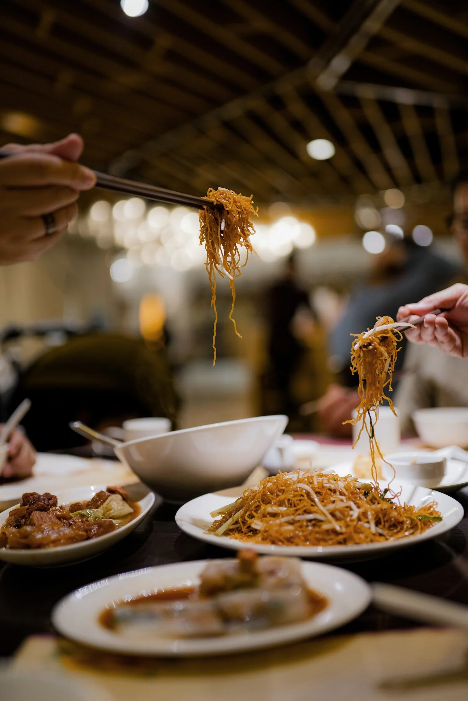 Guests sharing Cantonese dishes around a table